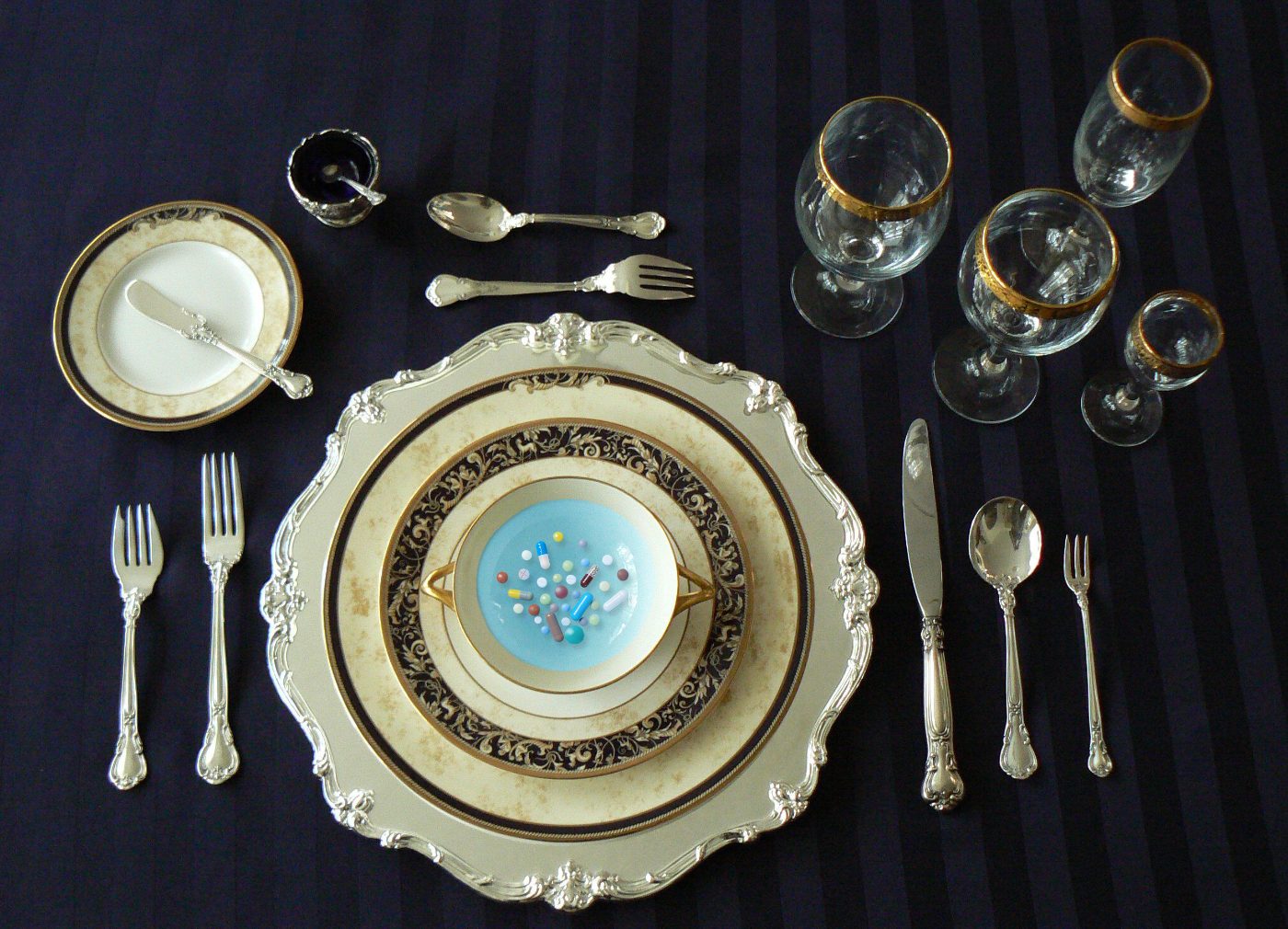 Formal table setting with a plate of pills served as a meal