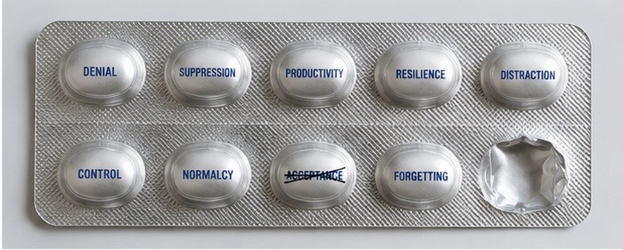 Pill blister pack with tablets labeled Denial, Suppression, Productivity, Resilience, Distraction, Control, Normalcy, Acceptance crossed out, and Forgetting